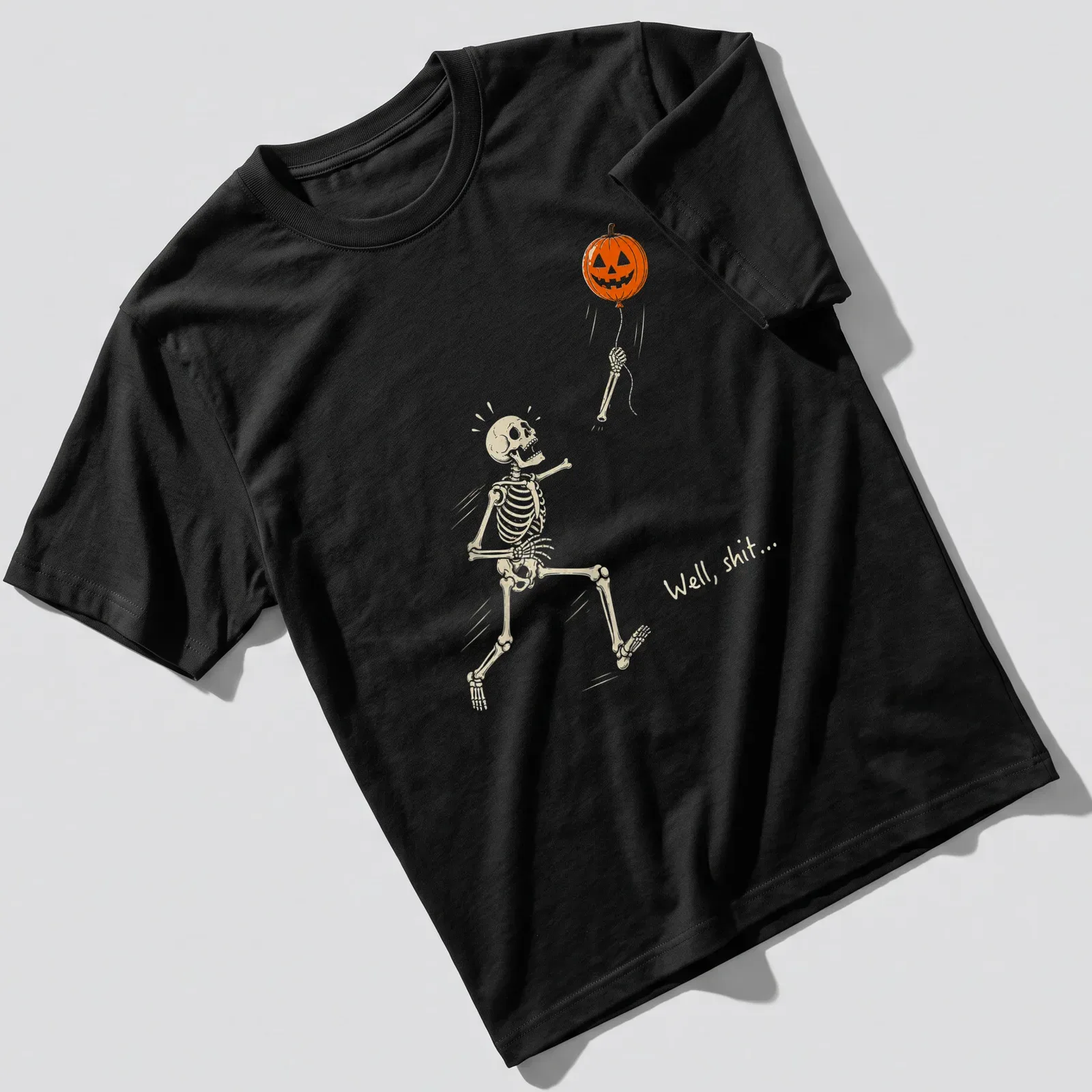 Cartoon skeleton chasing a pumpkin balloon with humorous text above — printed on a unisex t-shirt