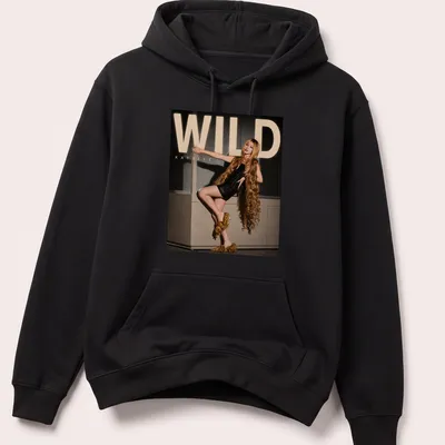 Bold WILD Katseye text above an illustration of a fashion model in gold and black — printed on a unisex hoodie